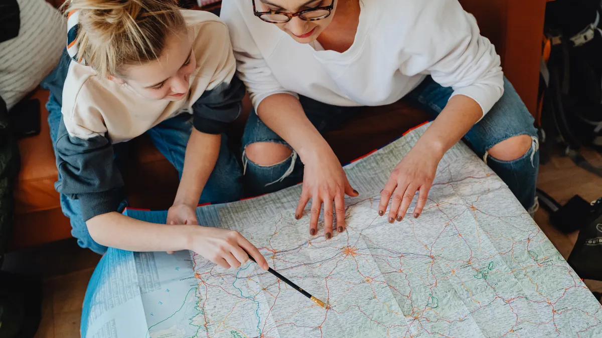 Best Budget Family Road Trip Stops in the US Adult and child pointing at a road map