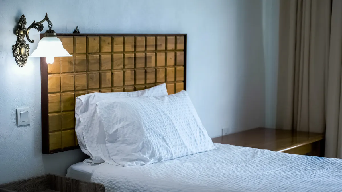 Best Budget Family Trip Stops Within a Short Drive of Major US Airports simple hotel bed in a small room