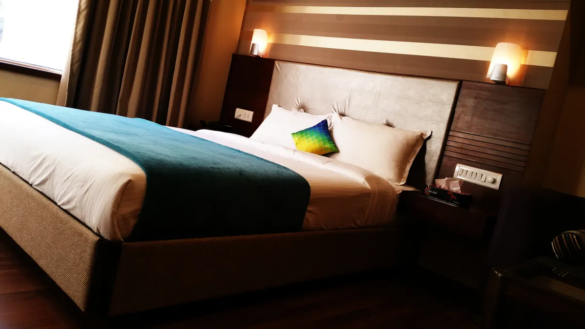 Best Budget Family Trip Stops Within a Short Drive of Major US Airports hotel bedroom with bed and bedside lighting