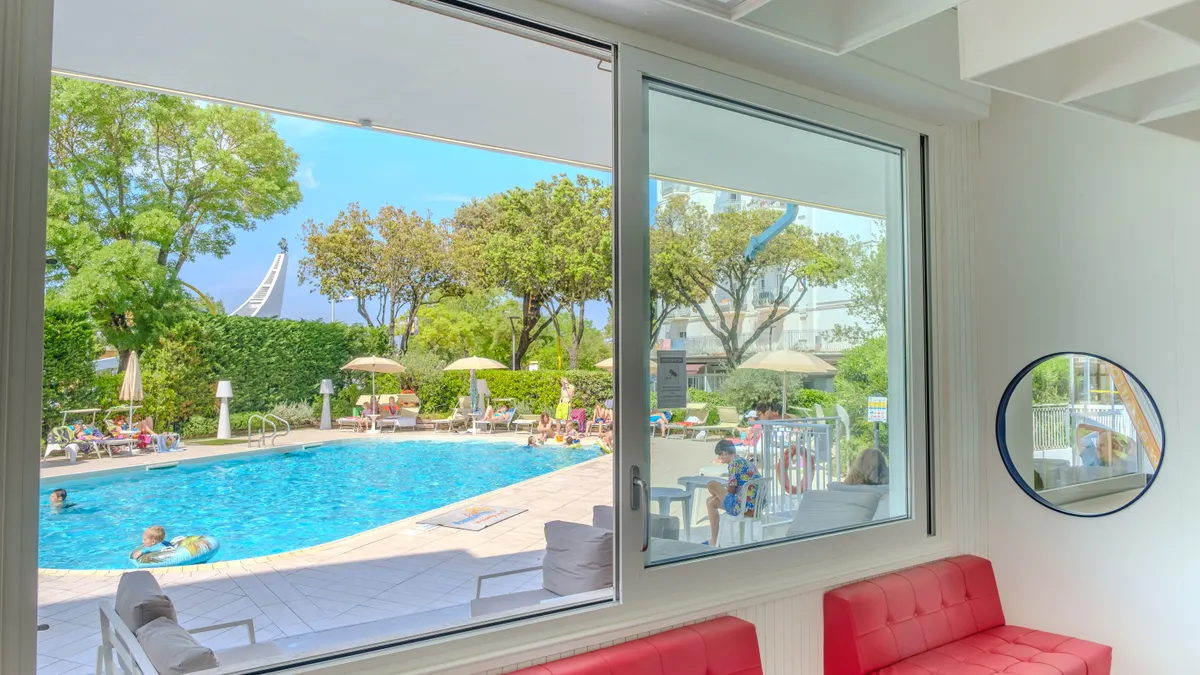 Room with large window overlooking a hotel pool