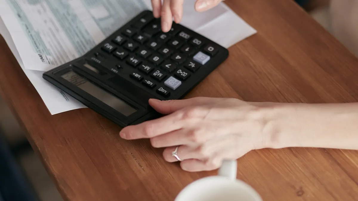 hands using a calculator over paperwork