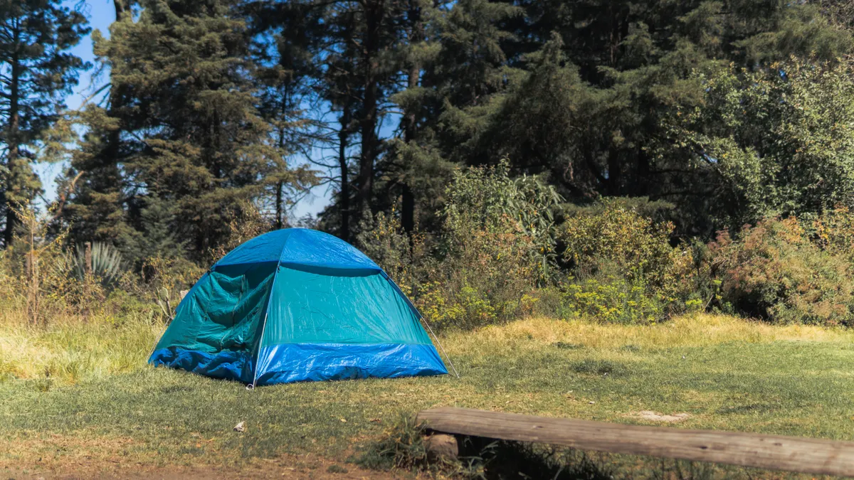blue tent in a forested campsite