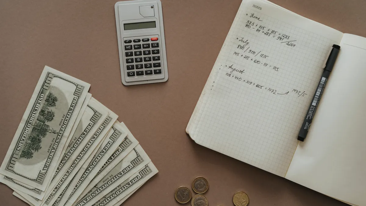 Cheap Family Cabins and Cottages Guide Cash, calculator, and budget notebook on a desk
