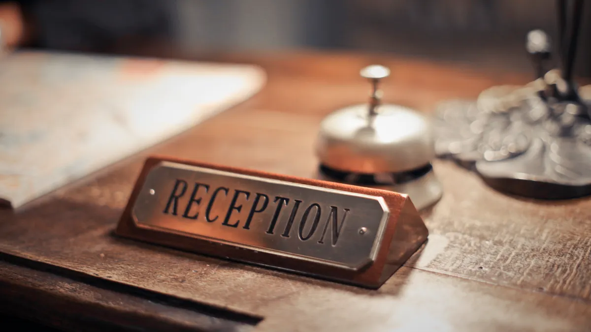 Hotel reception desk with bell and sign